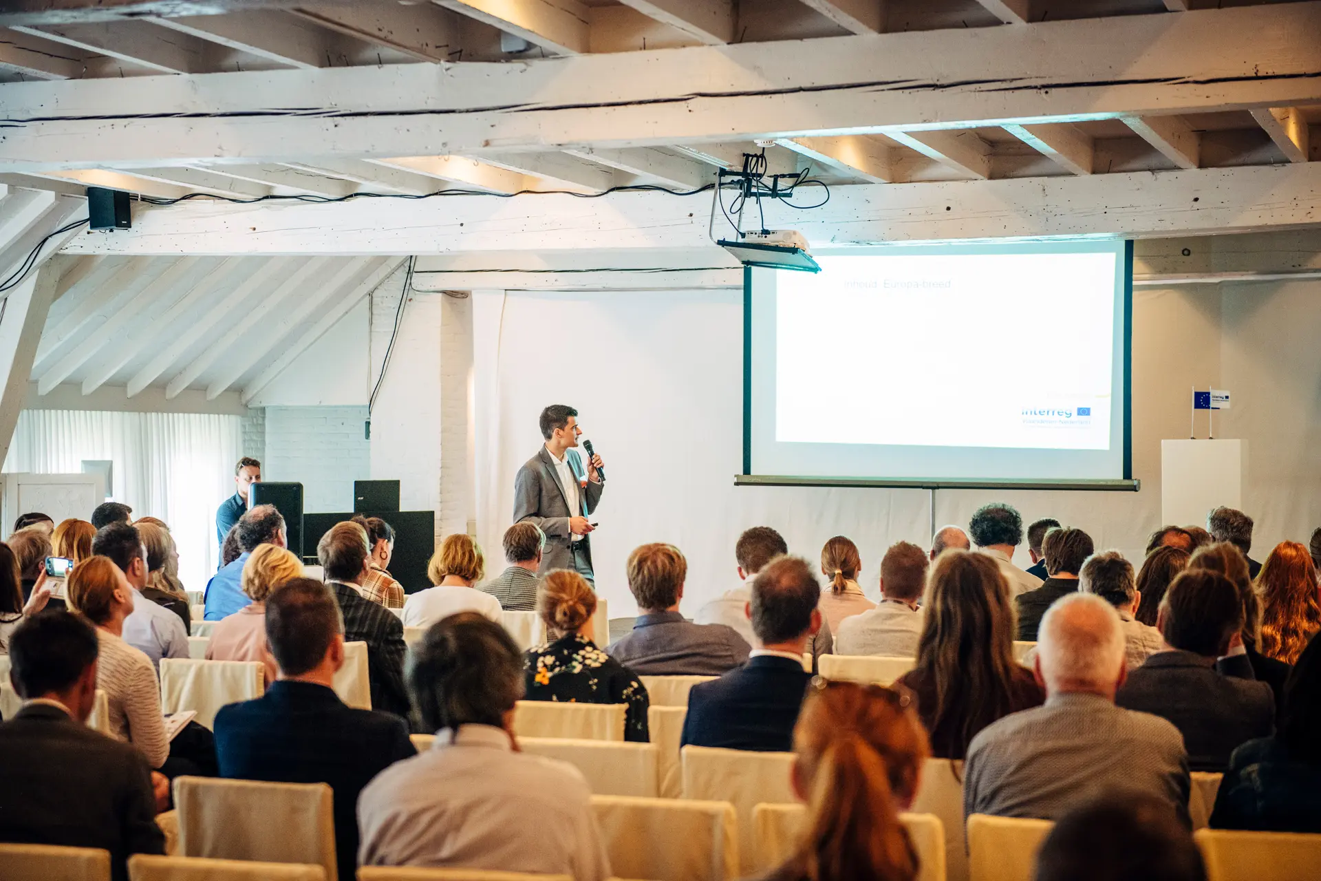 Spreker voor een volle zaal tijdens een opleiding