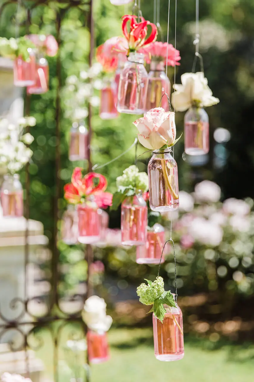 Hangende flesjes met bloemen als ceremoniedecoratie