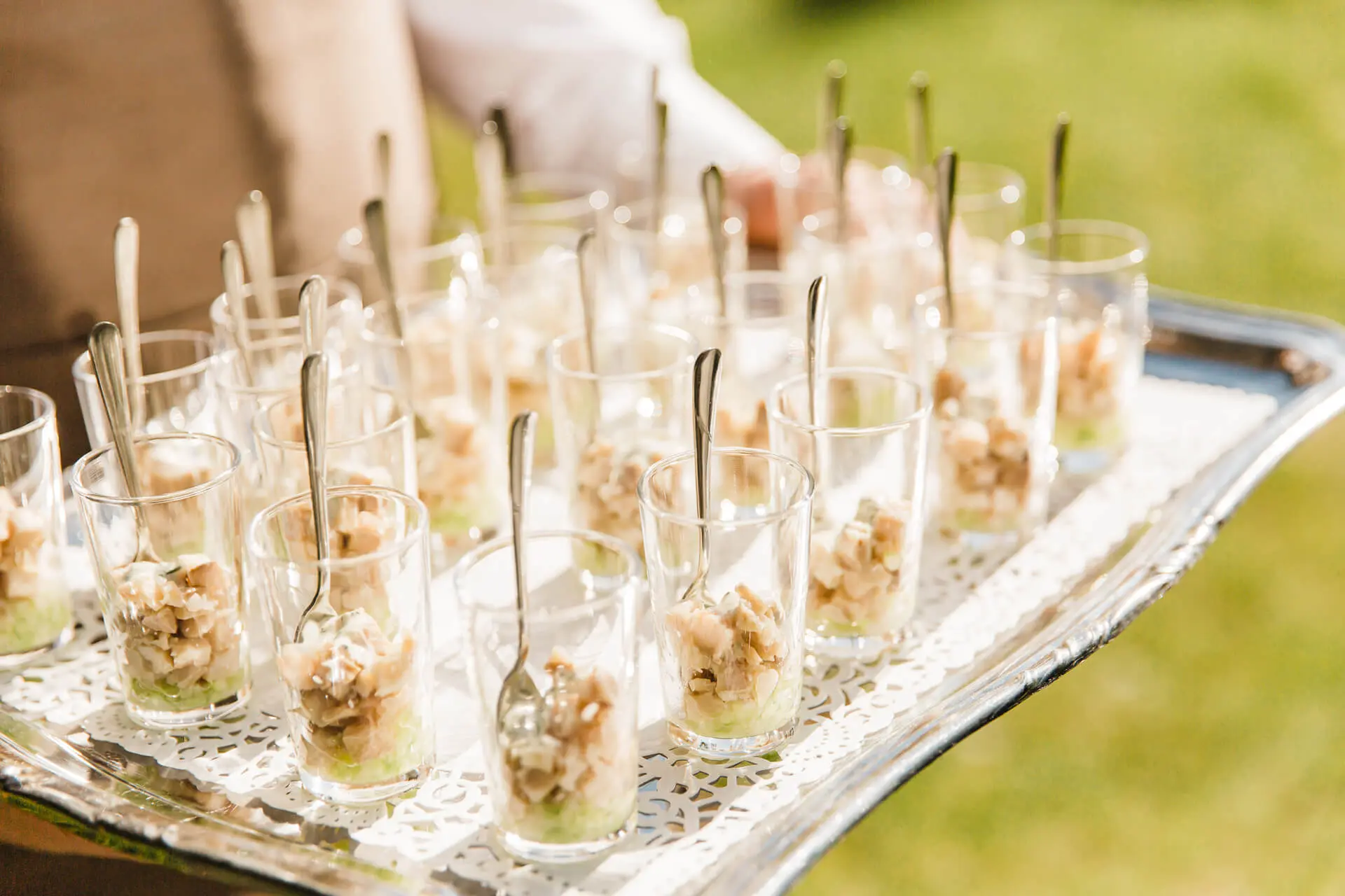 Aperitiefhapjes in glaasjes op een zilveren schaal