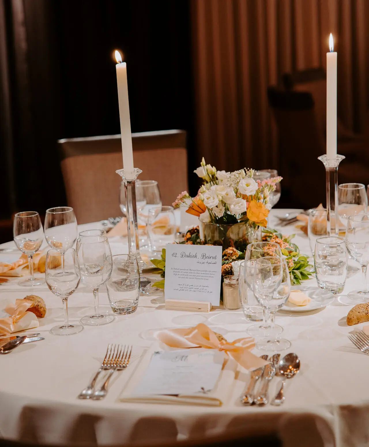 Gedekte feesttafel met kaarsen, bloemen en menukaartjes in Alta Ripa