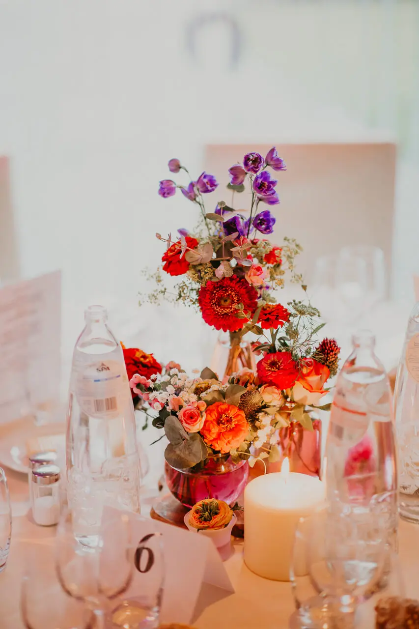 Tafeldecoratie met rode en oranje bloemen