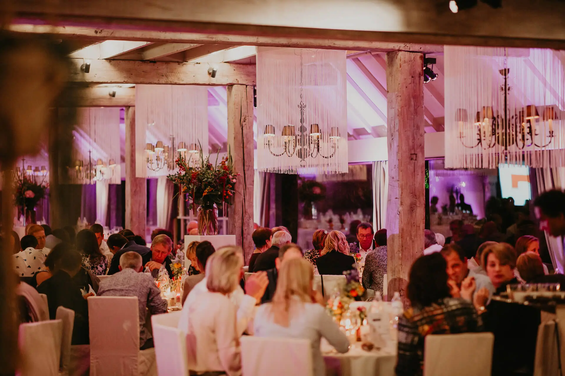 Gasten aan tafel tijdens een diner in de grote zaal