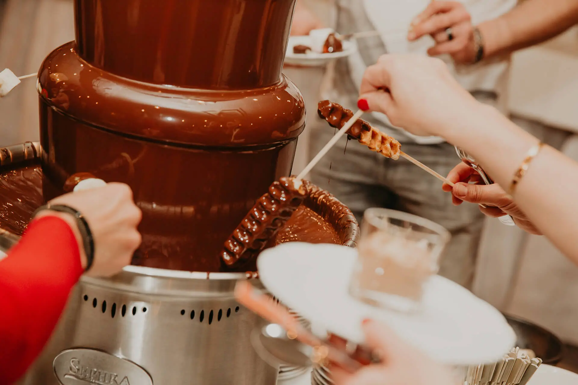 Gasten dopen spiesjes in de chocoladefontein