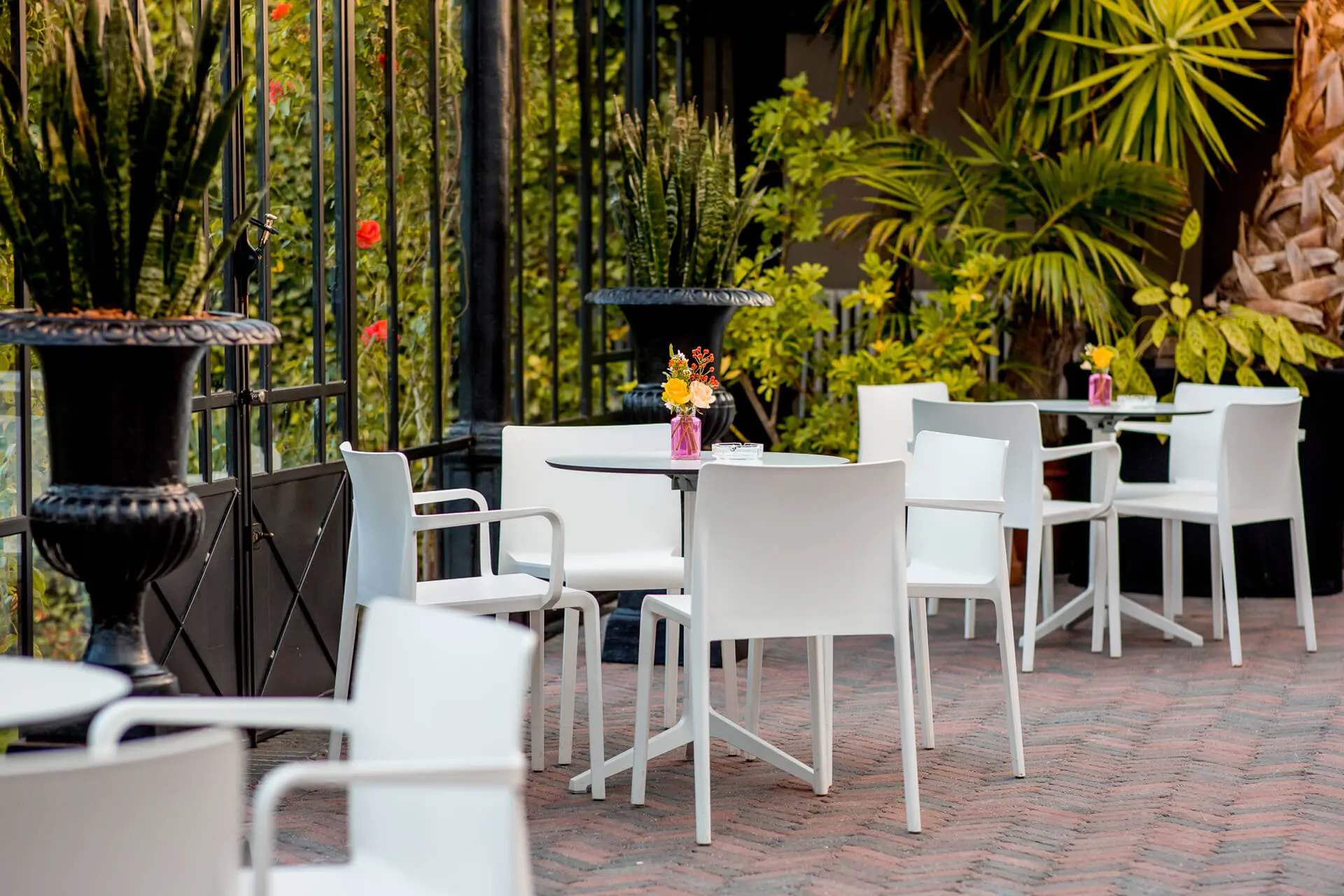 Witte tafels en stoelen tussen de planten in de orangerie van de grote zaal