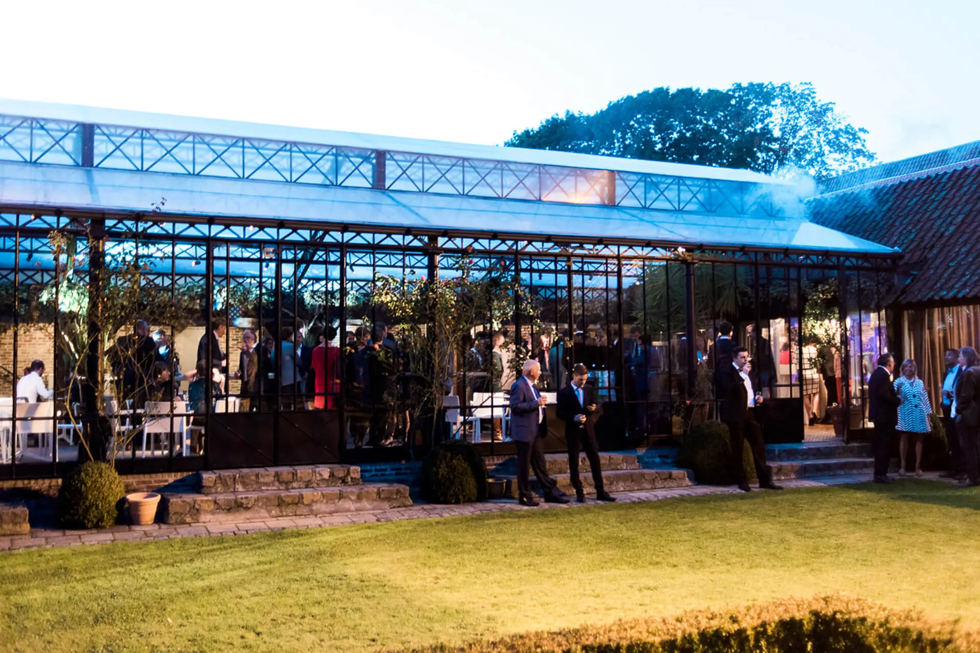 Orangerie van de grote zaal bij valavond, gezien vanuit de tuin