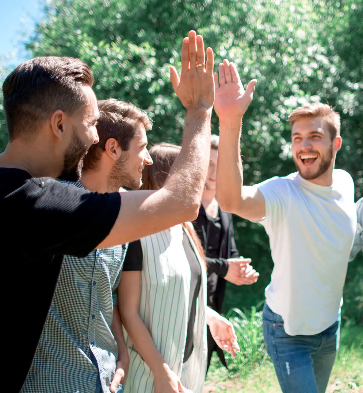 Collega’s geven elkaar buiten een high five tijdens een teambuilding