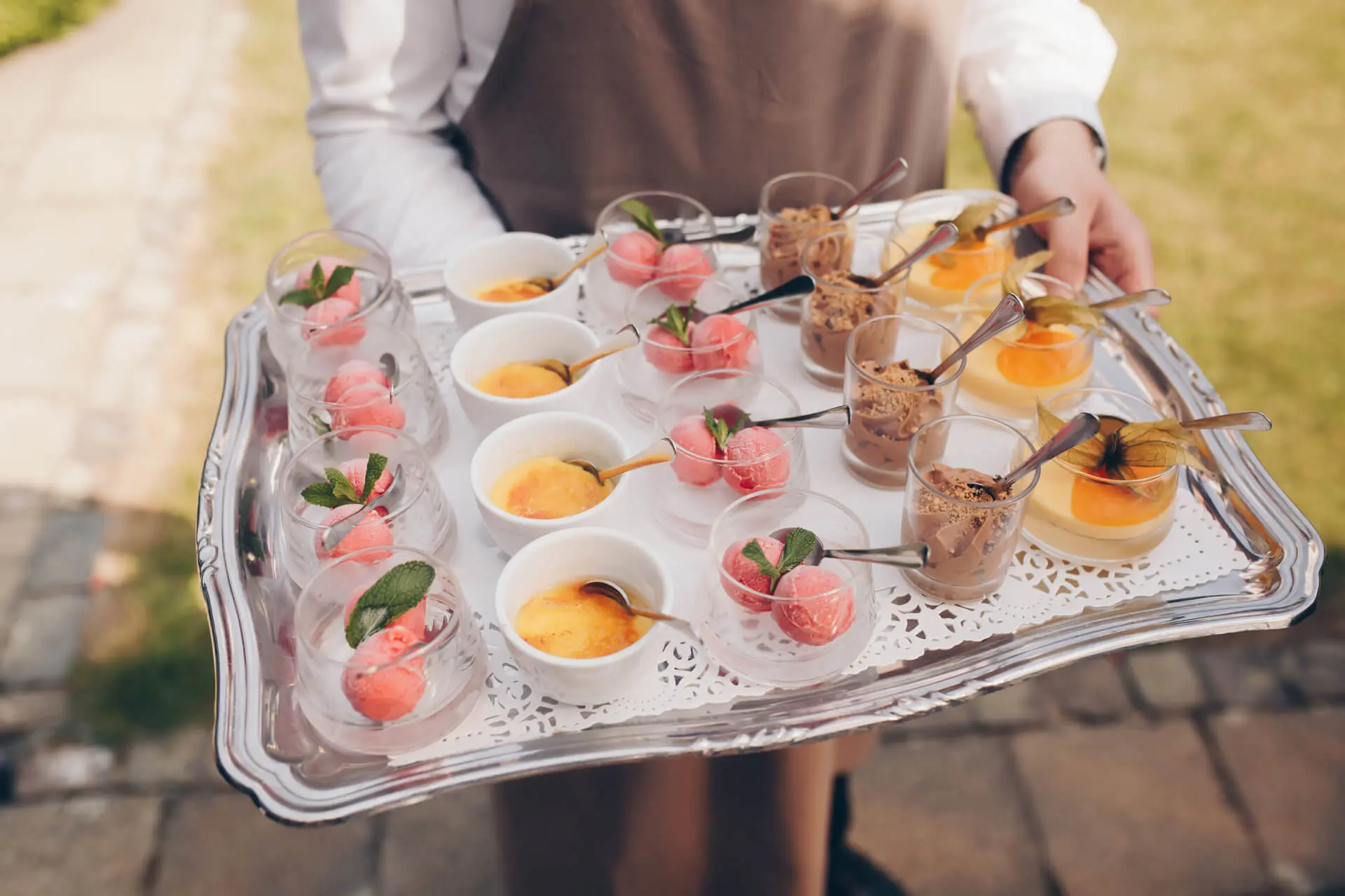 Ober draagt een schaal met kleine dessertjes