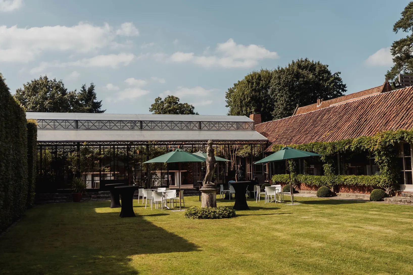 De tuin van Alta Ripa met terras en orangerie op een zonnige dag