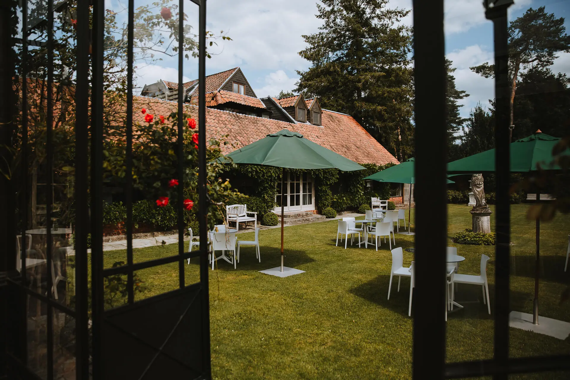 Tuin met parasols, gezien door de open deuren van de orangerie