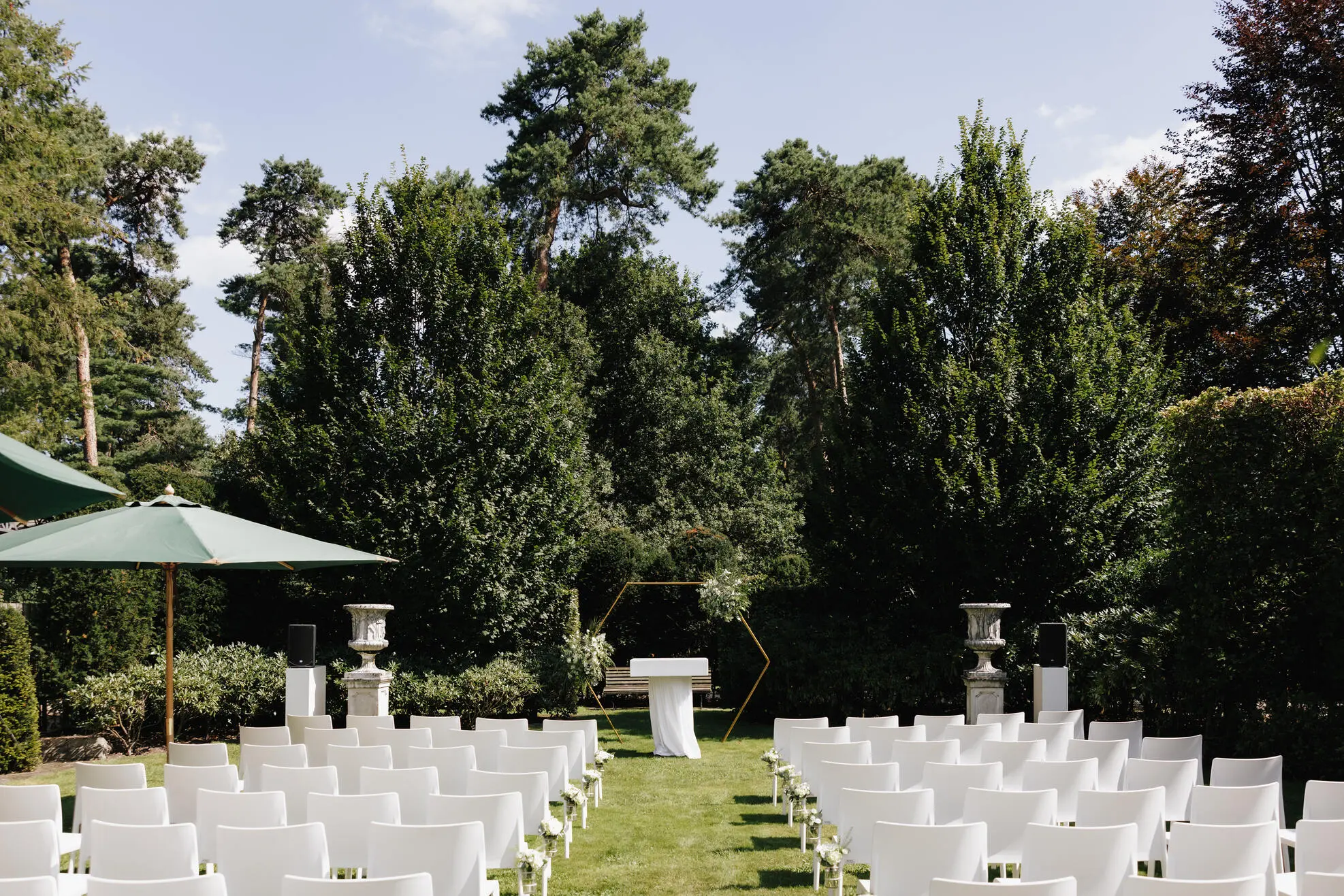Ceremonie-opstelling met witte stoelen in de tuin van Alta Ripa in de Kempen