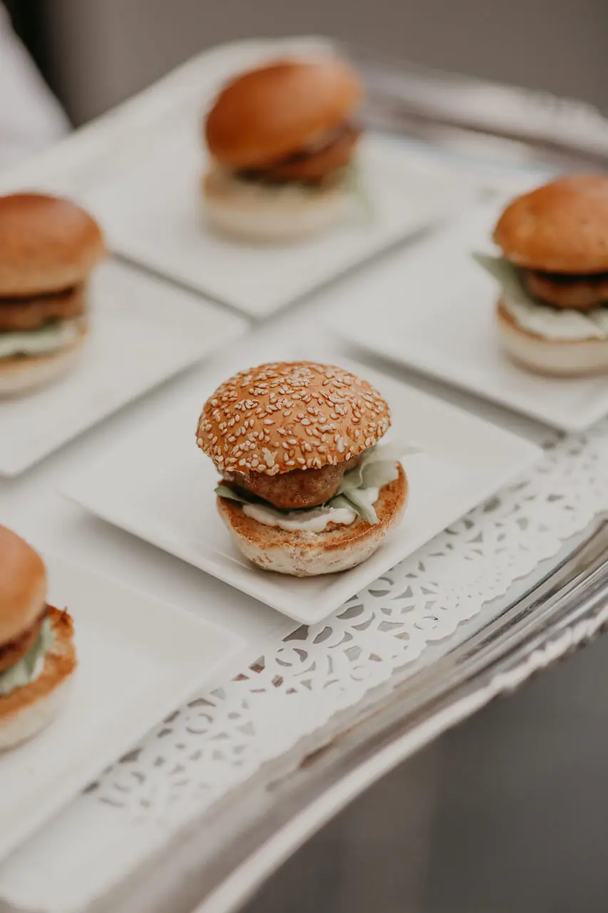 Mini-hamburgers geserveerd op witte bordjes