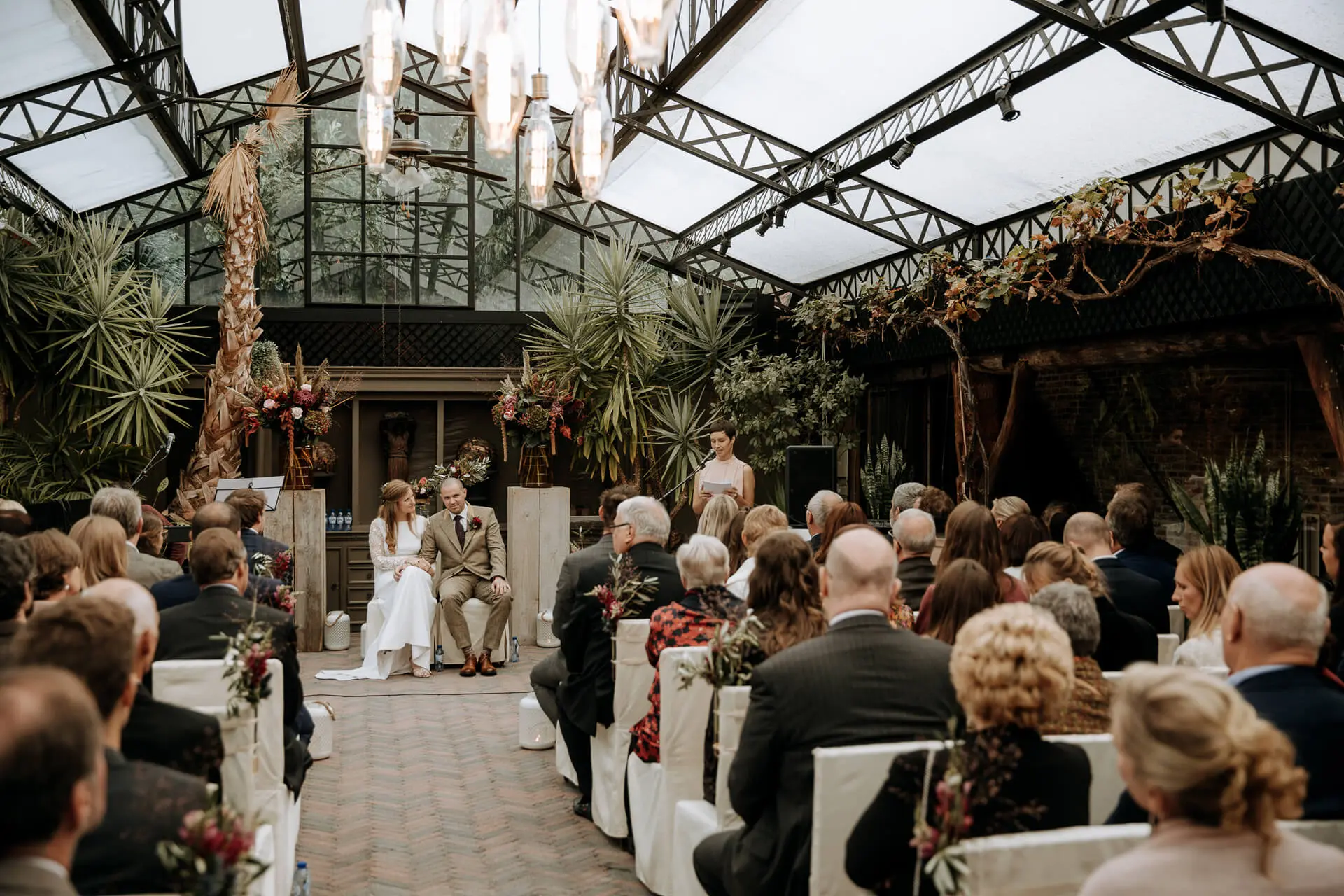 Huwelijksceremonie in de orangerie van de grote zaal, gezien vanaf de achterste rijen