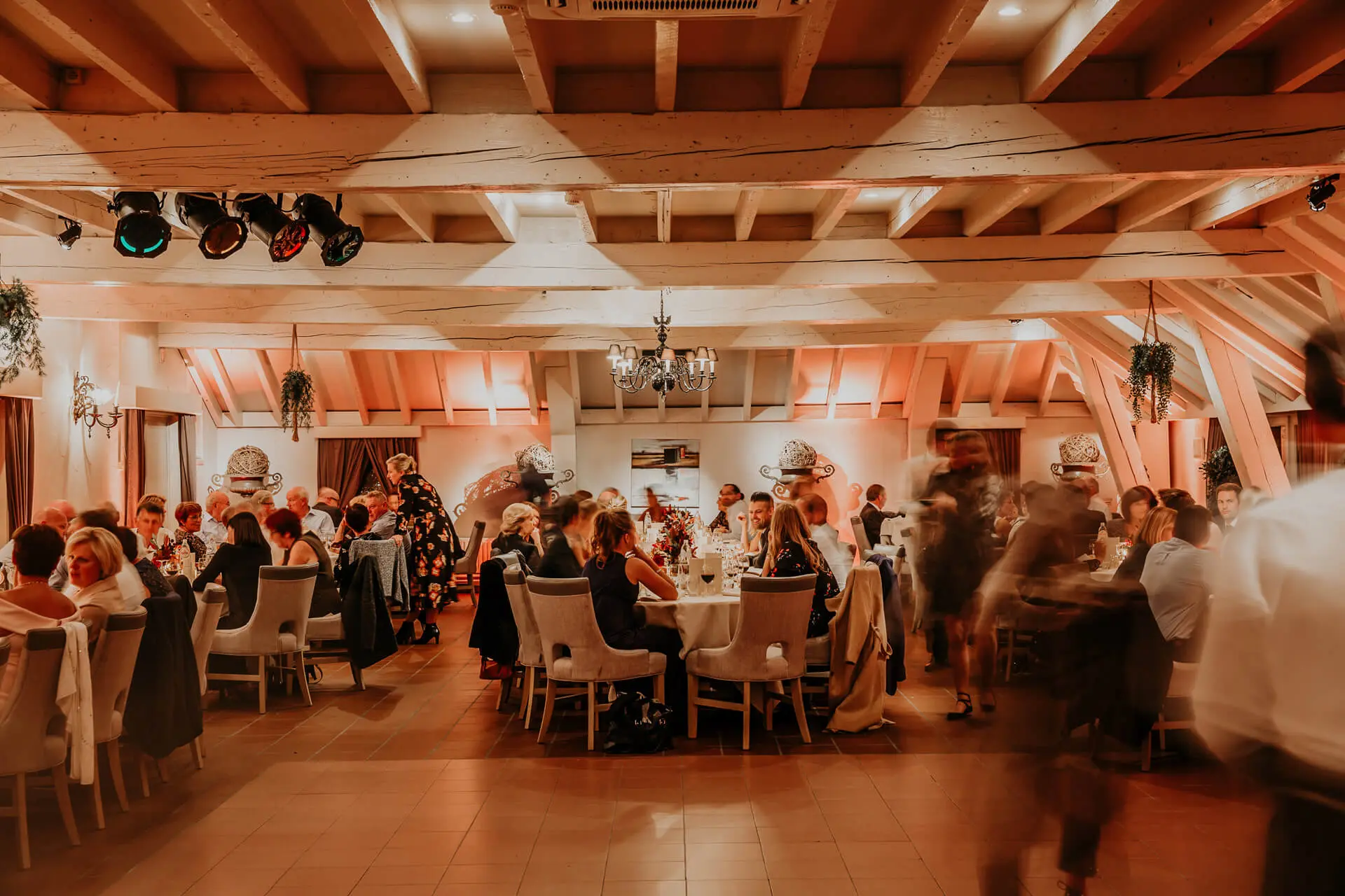 Gasten aan ronde tafels tijdens een diner in de kleine zaal