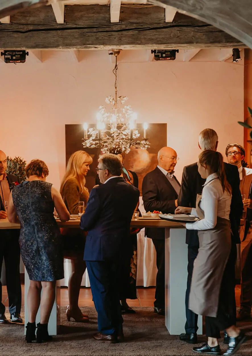 Gasten aan een hoge tafel tijdens het aperitief in de kleine zaal
