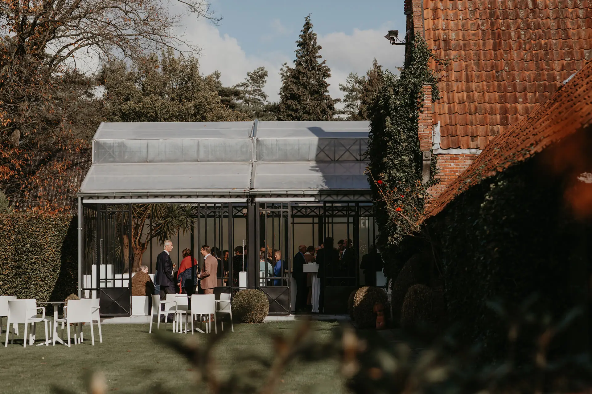 Gasten in de orangerie van de kleine zaal, gezien vanuit de tuin