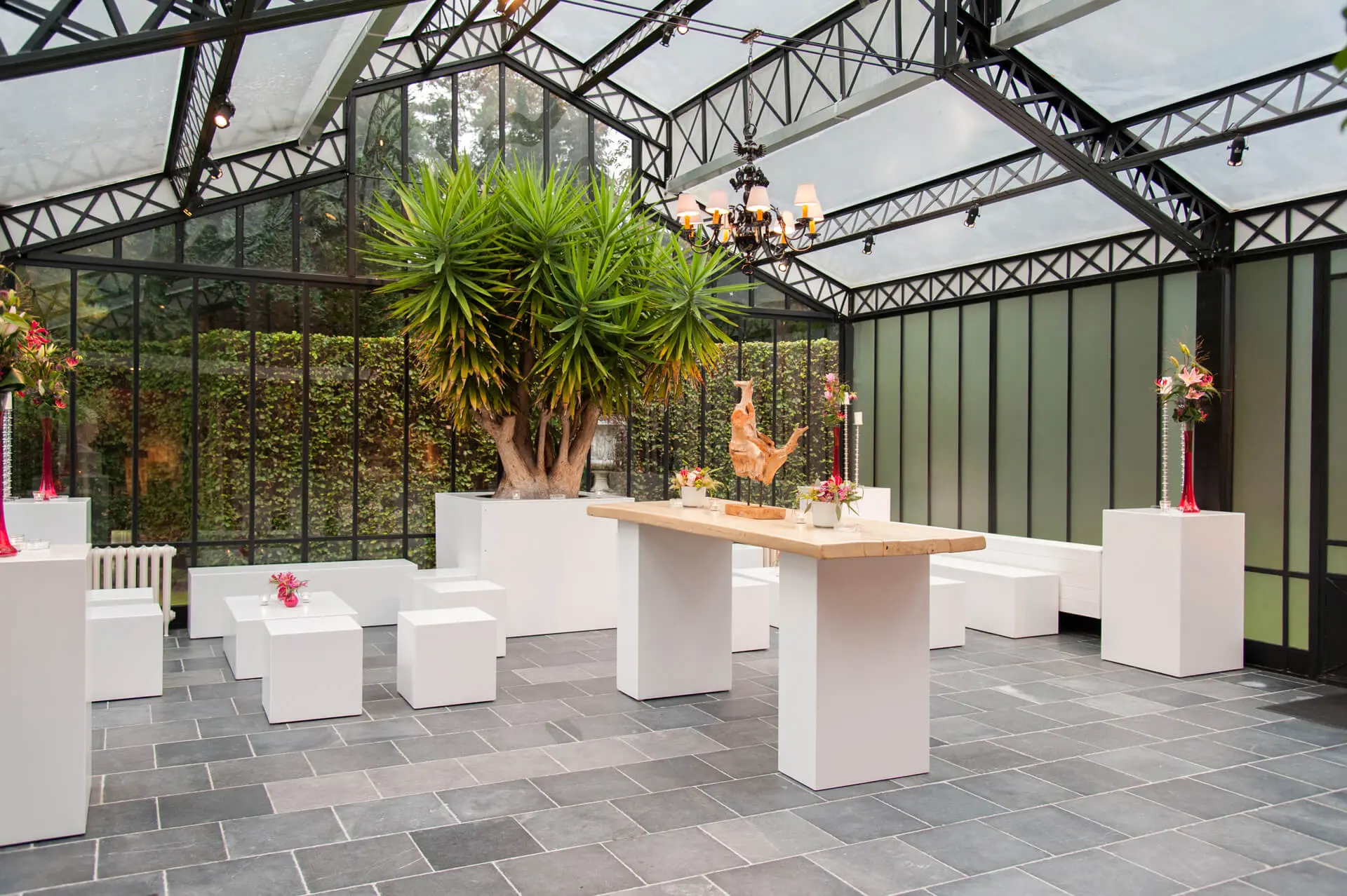 Orangerie van de kleine zaal met witte zitblokken en hoge tafels