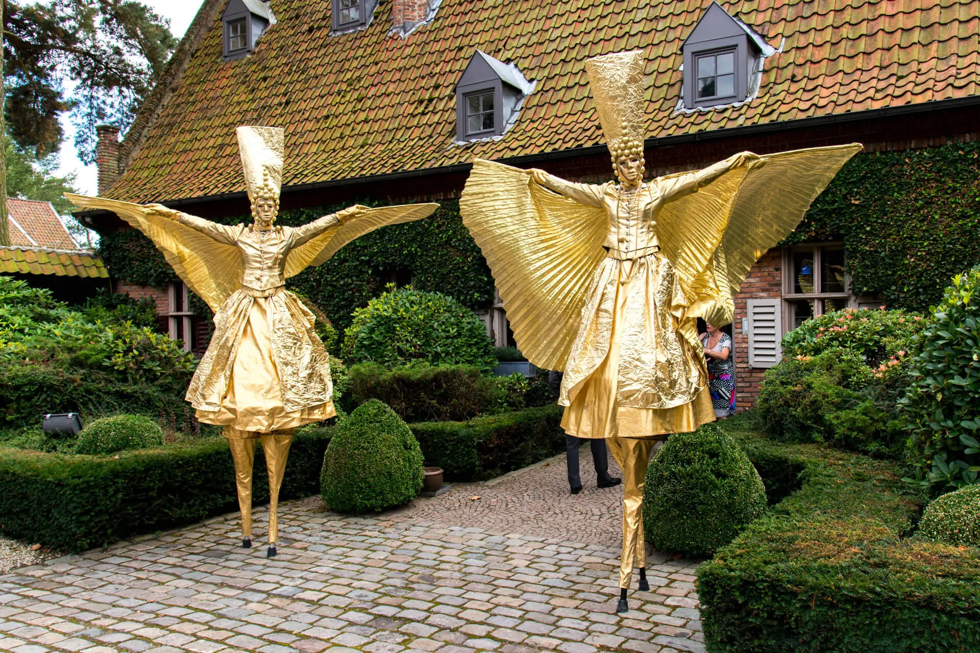 Gouden steltlopers met vleugels als animatie voor het gebouw van Alta Ripa