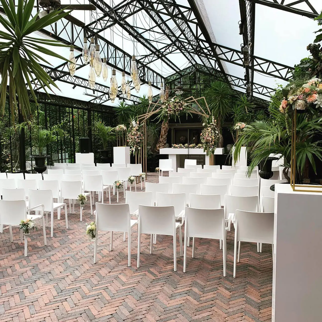 Orangerie van de grote zaal met witte stoelen in rijen voor een ceremonie