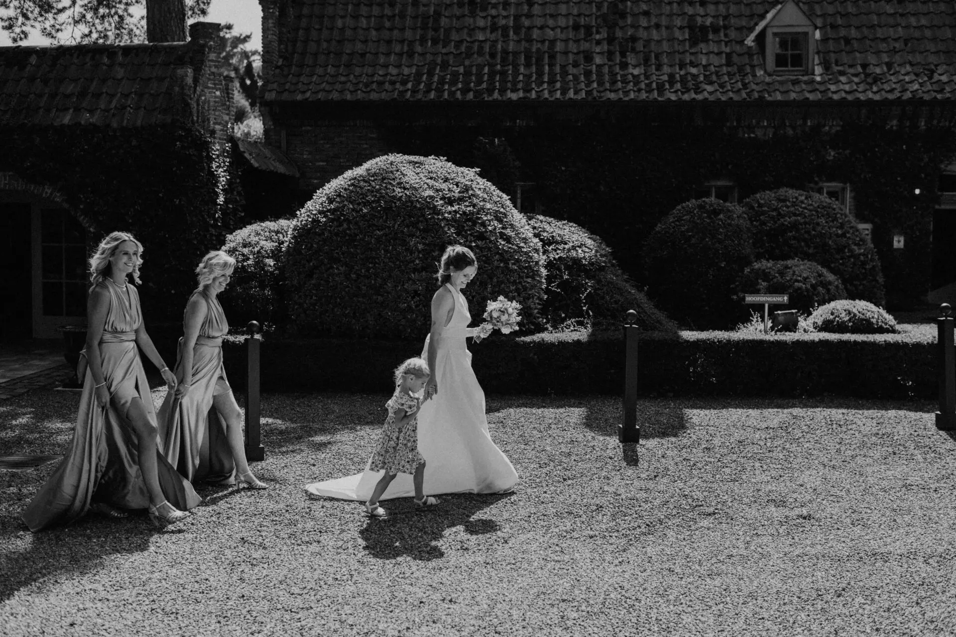 Bruid wandelt met bruidsmeisjes door de tuin van Alta Ripa