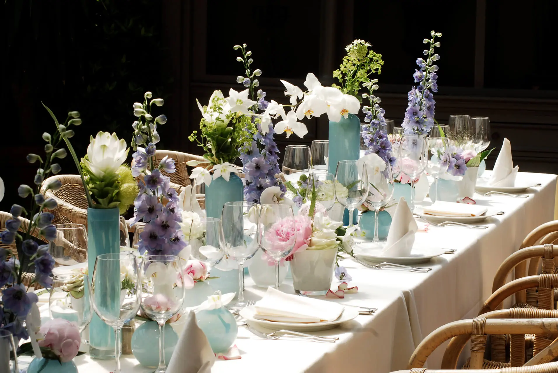Lange tafel met blauwe vaasjes en witte bloemen