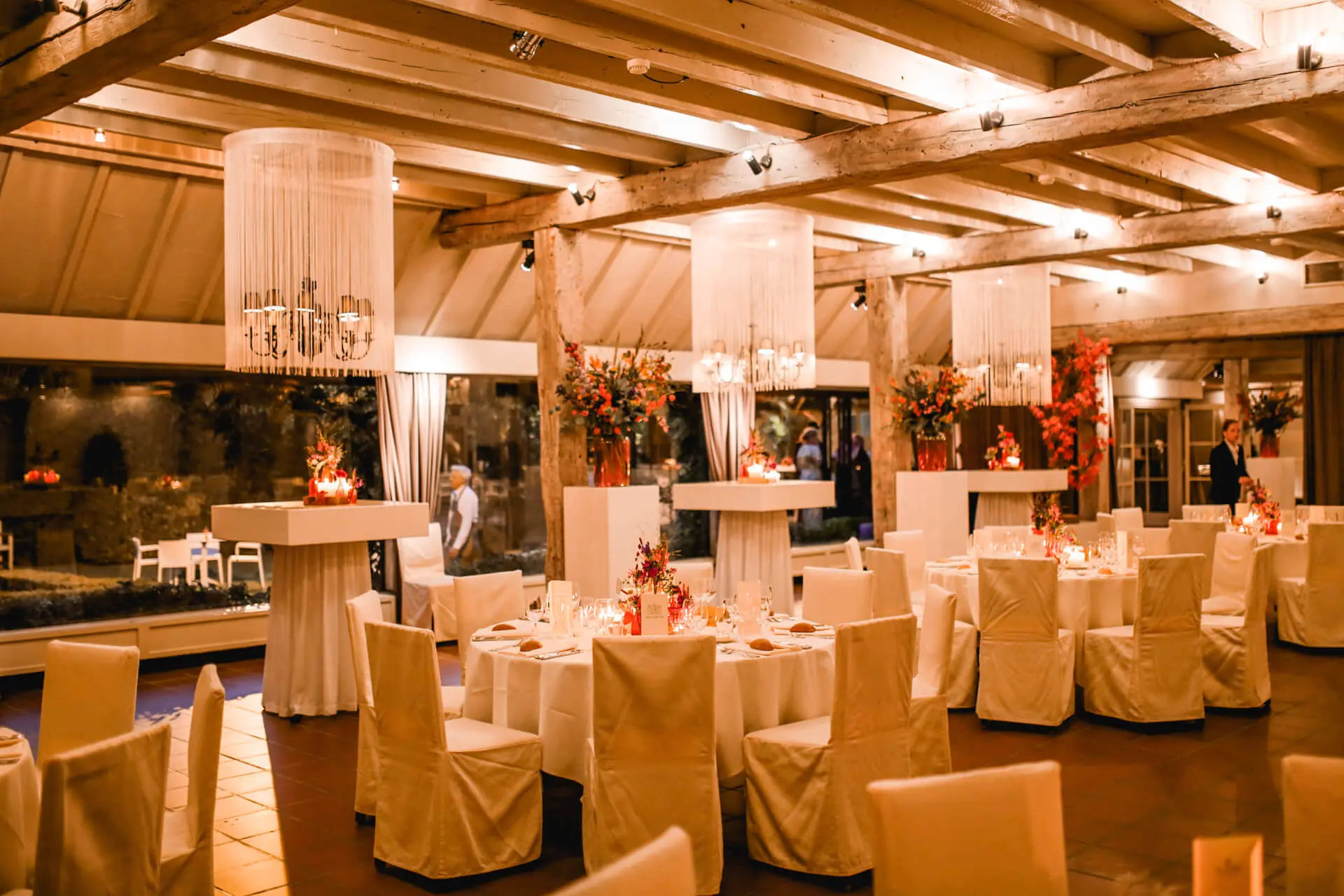 Grote zaal met hoge tafels en gedekte tafels voor een diner
