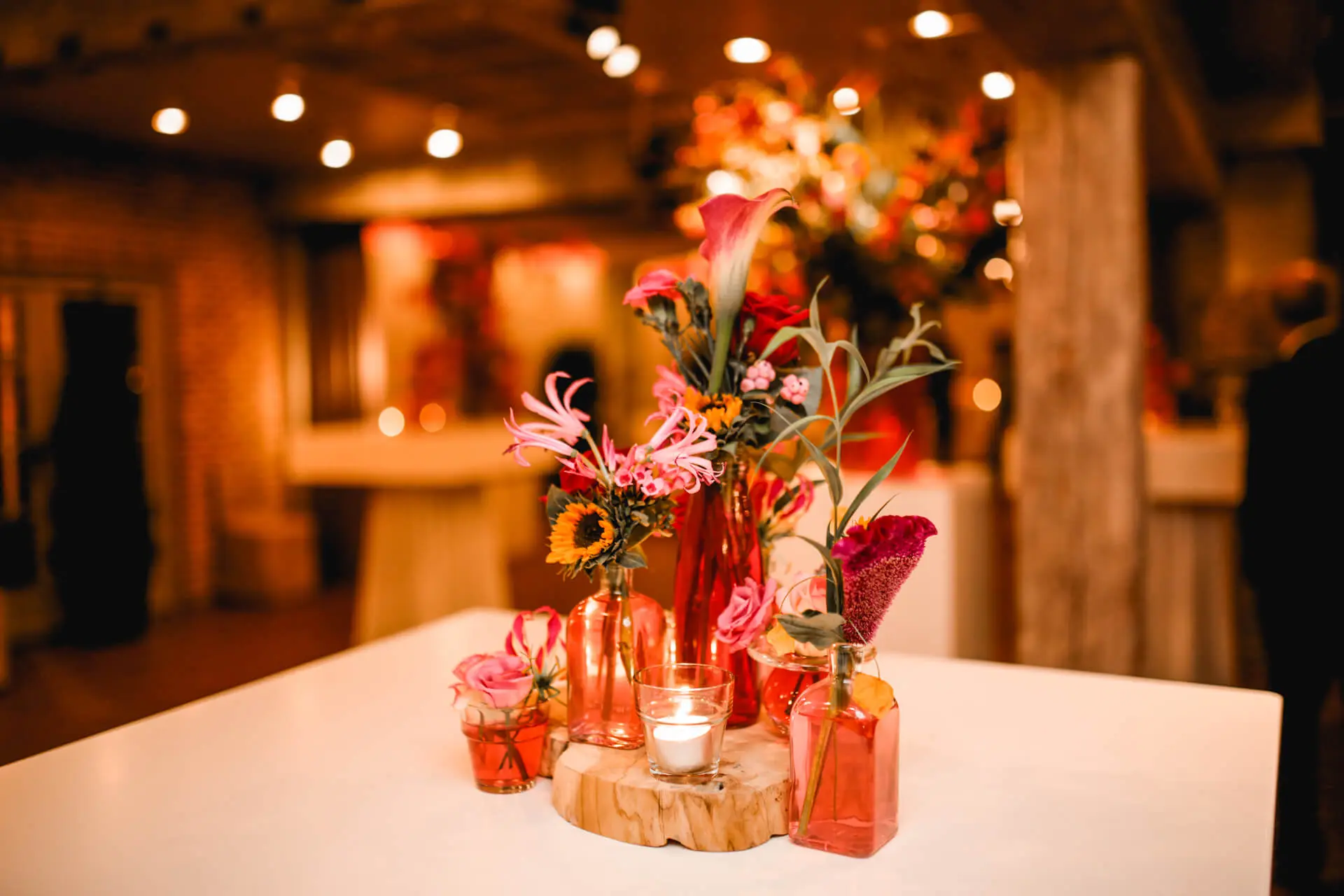 Tafeldecoratie met bloemen in rode vaasjes