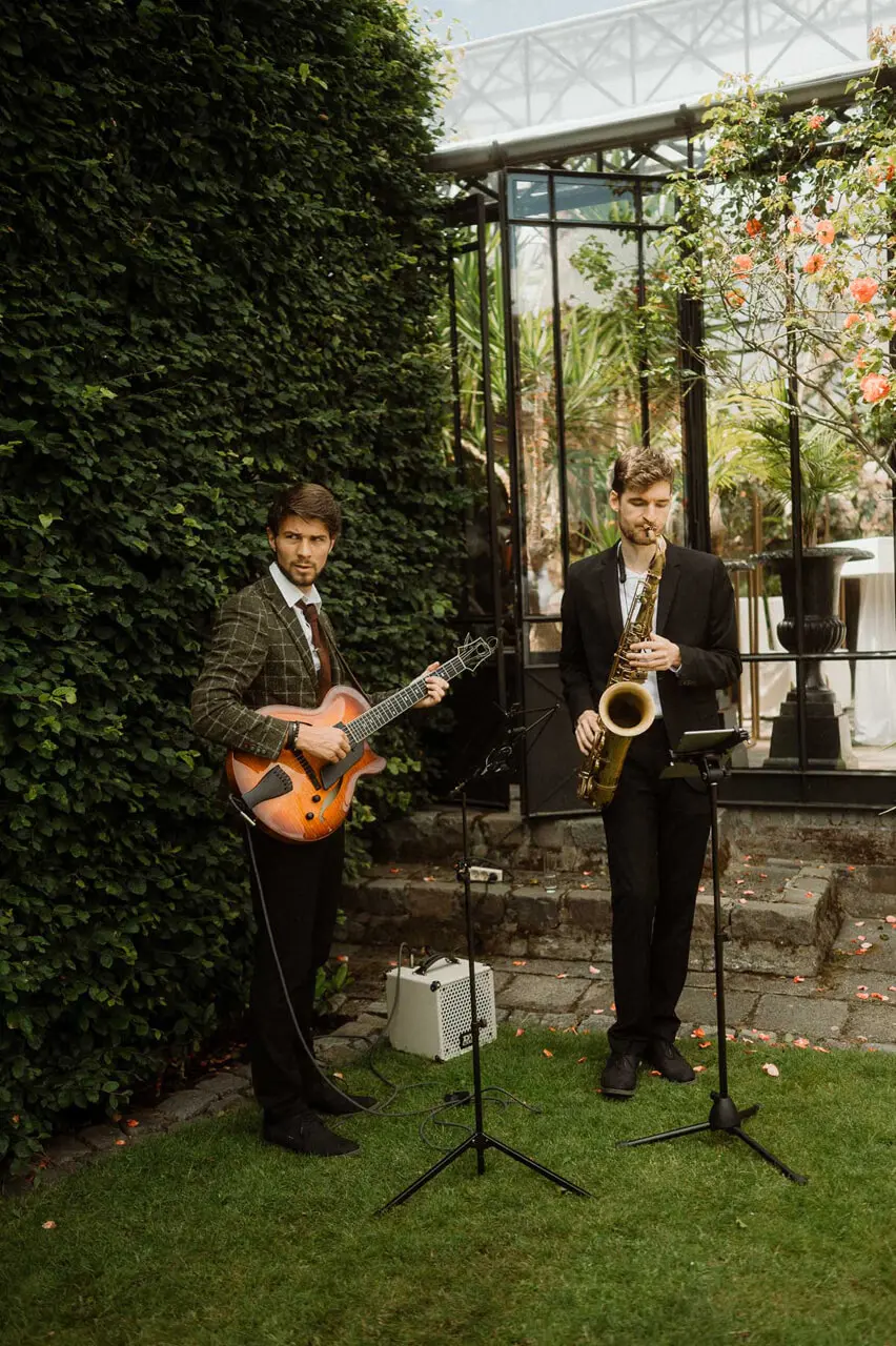 Gitarist en saxofonist spelen live in de tuin