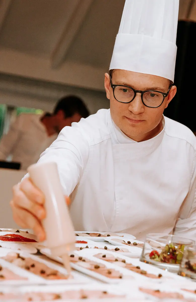 Chef-kok werkt gerechtjes af met een spuitzak