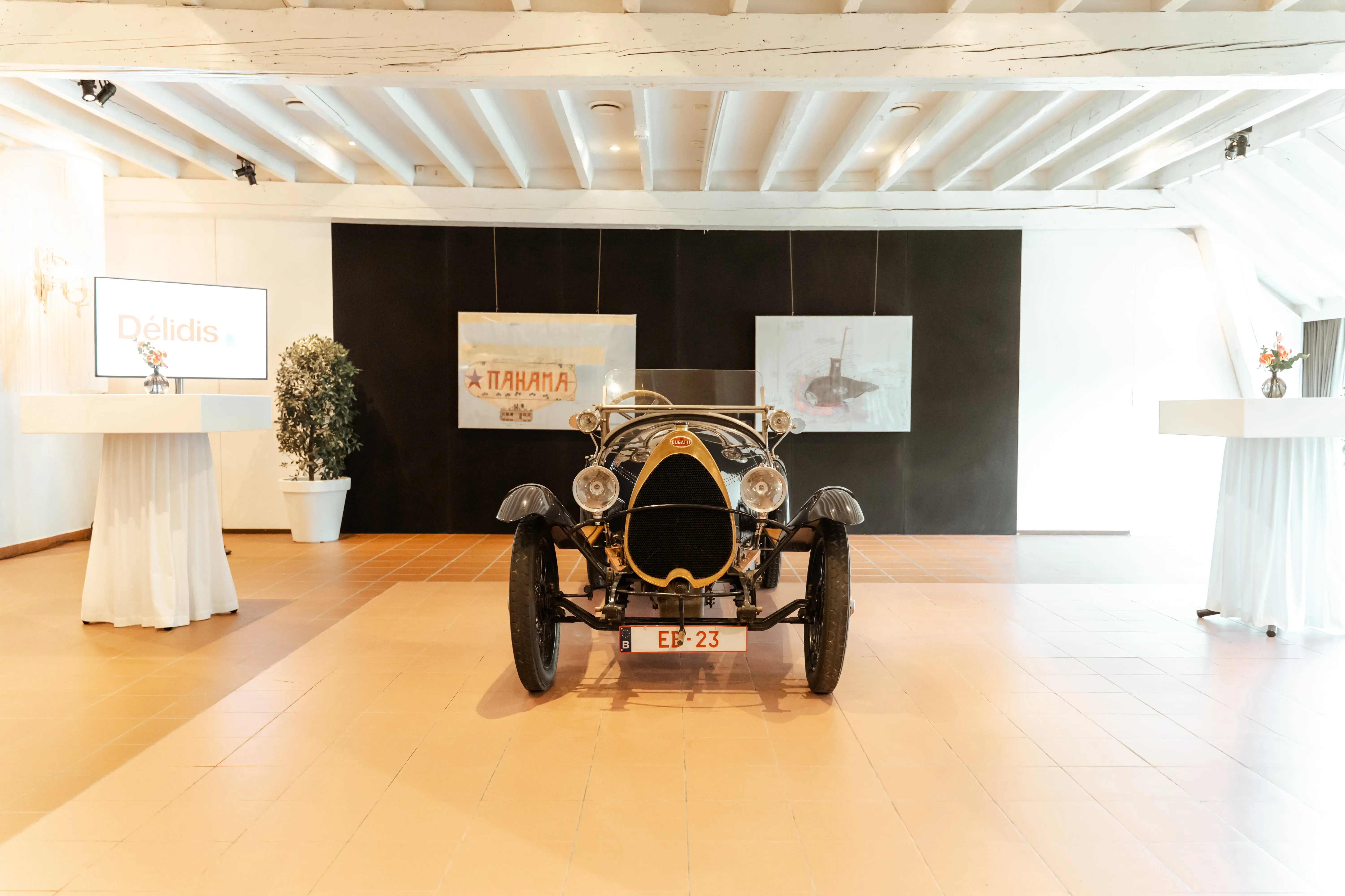 Oldtimer opgesteld in een witte zaal van Alta Ripa met statafels
