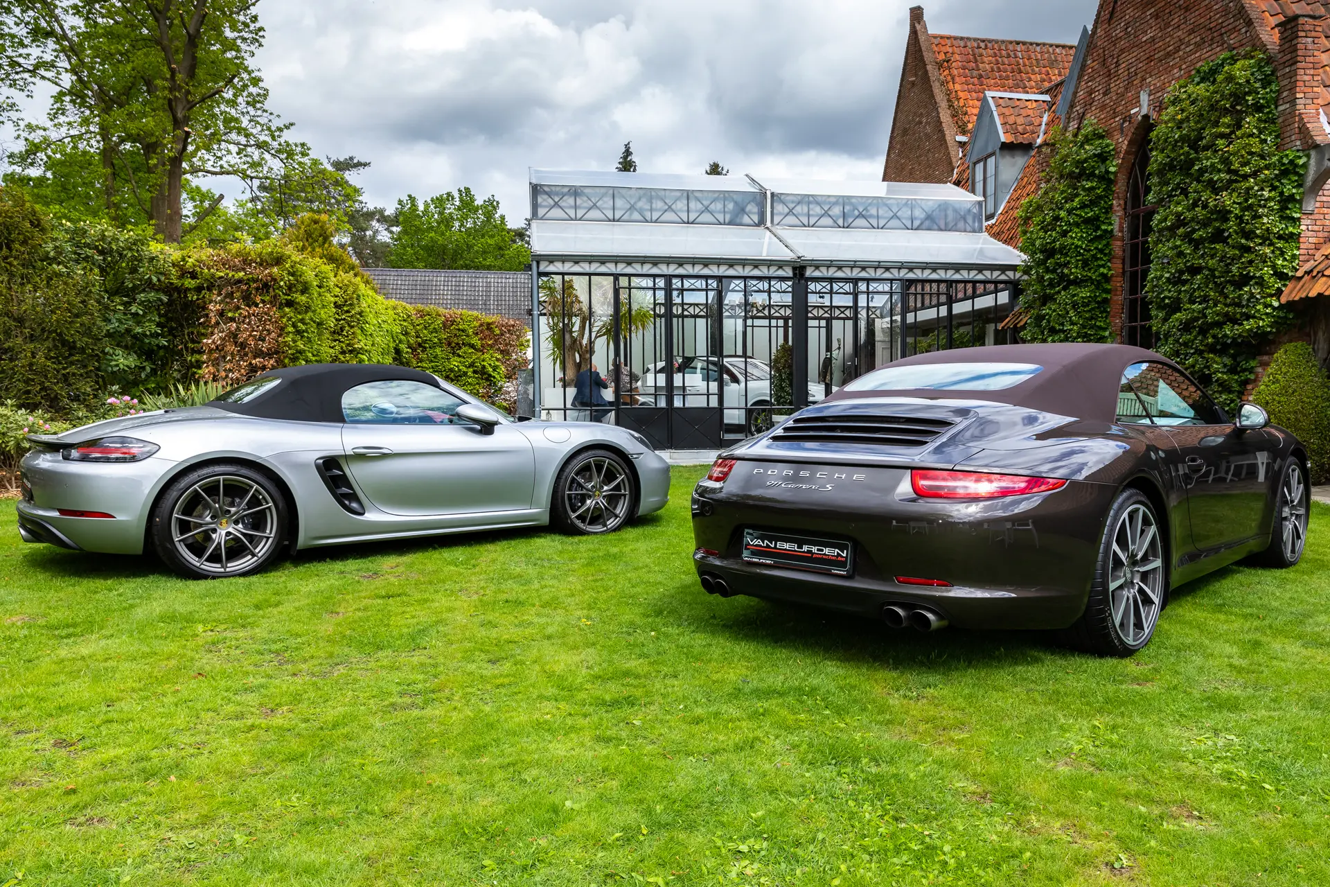 Twee Porsches op het gazon voor de orangerie