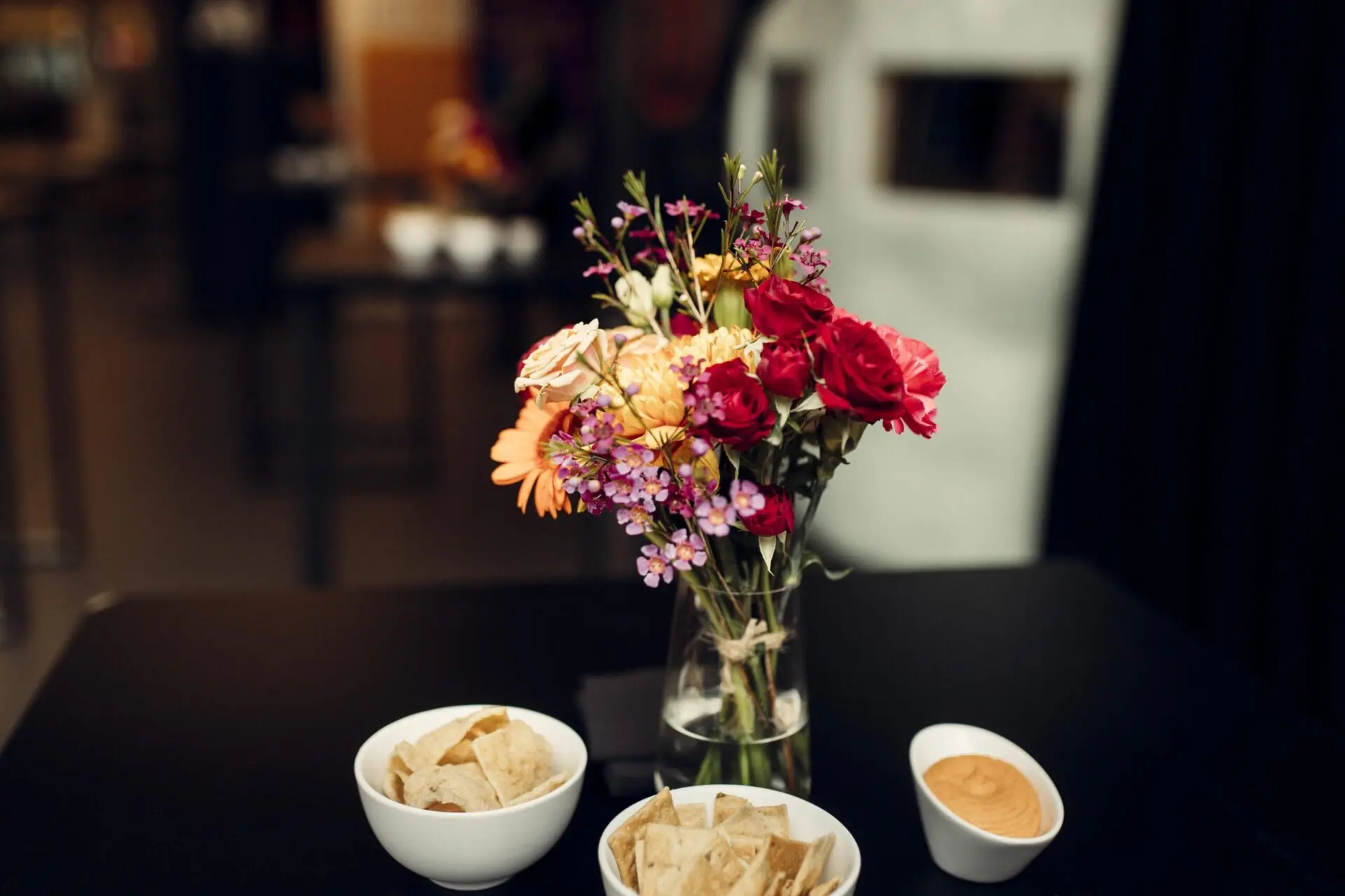 Statafel met bloemen en hapjes op een bedrijfsevent